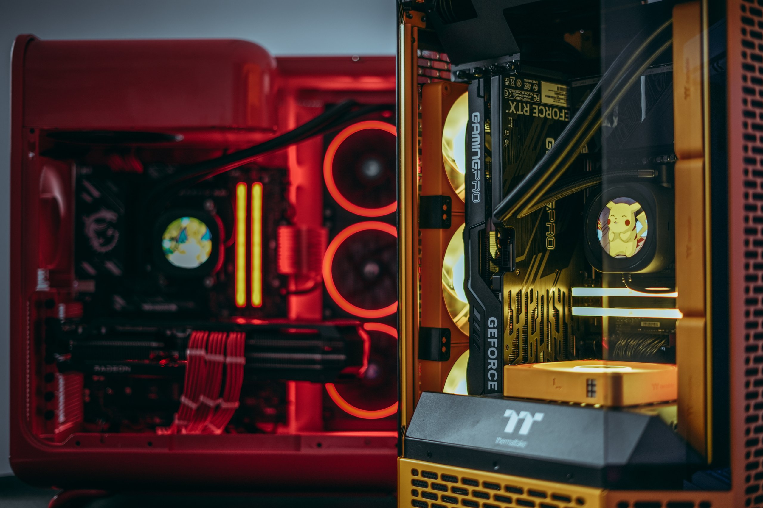 Two custom gaming PCs with red and yellow lit cooling loops